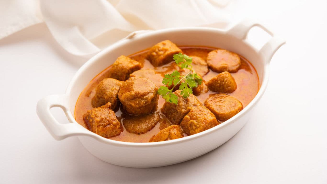 Delicious curry with meatballs in white bowl
