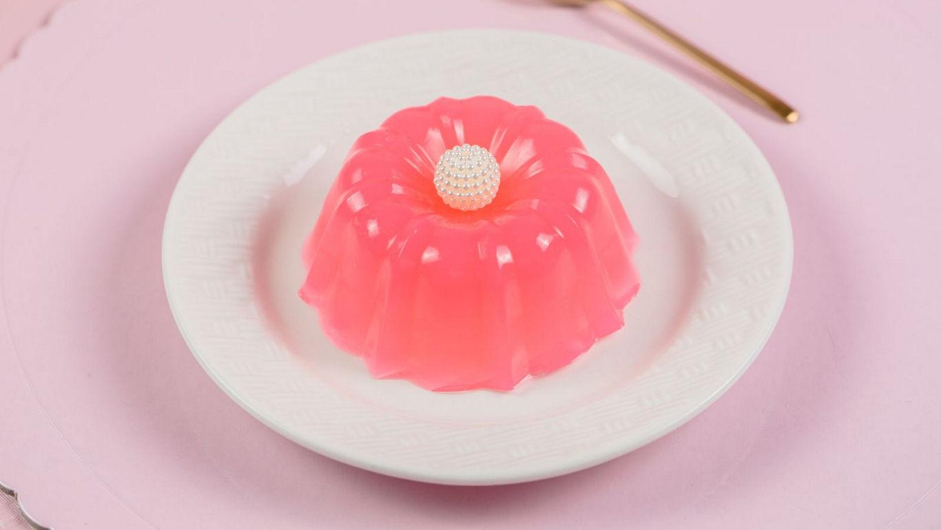 Pink gelatin dessert on white plate