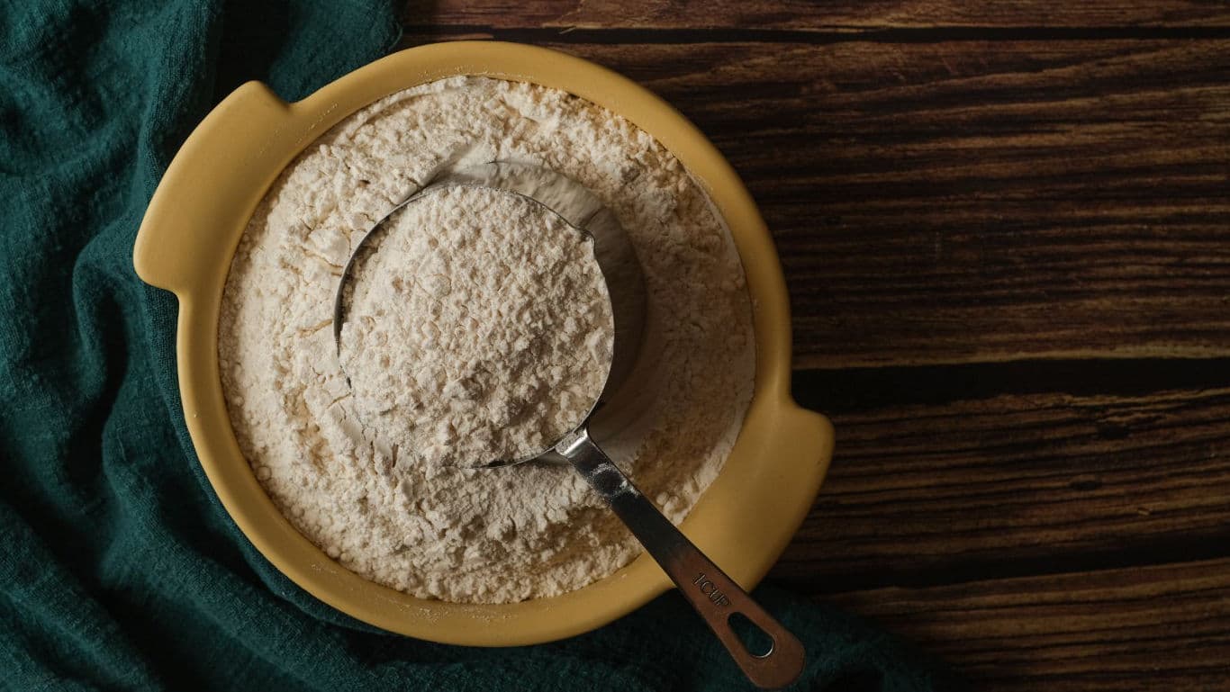 Metal measuring cup filled with flour