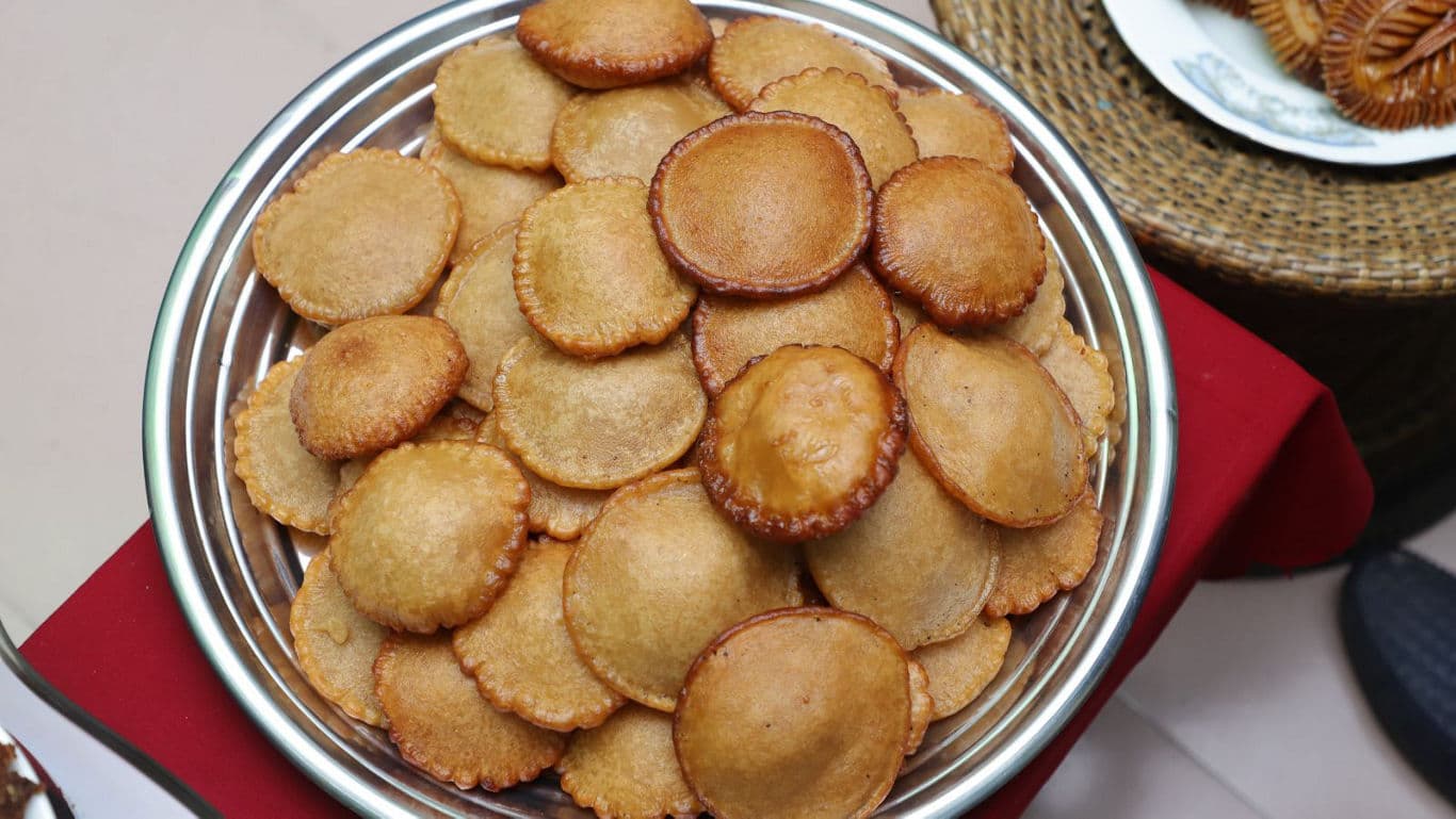 Bowl of golden brown fried pastries on table