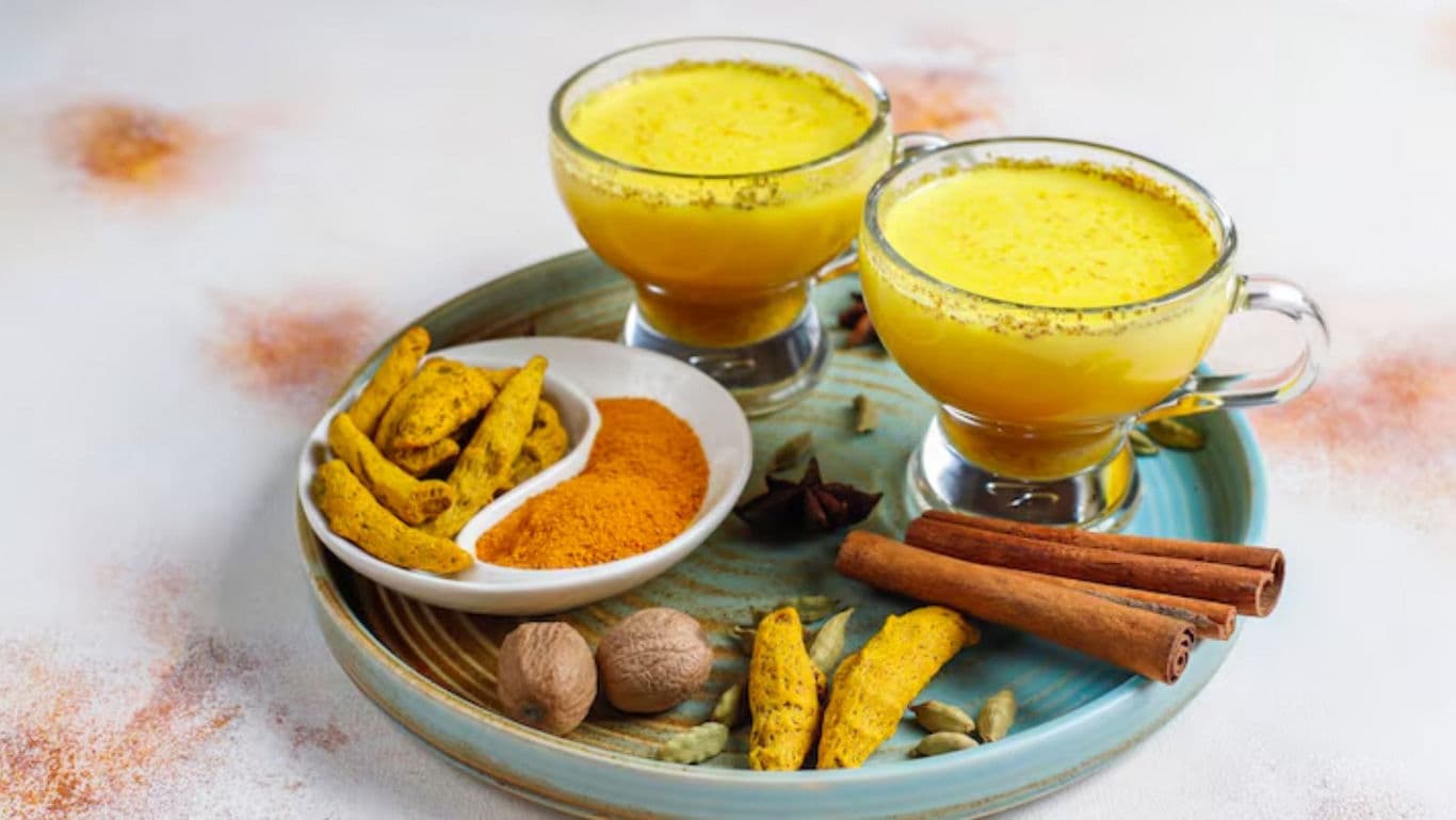 Two Glass Mugs of Golden Turmeric Milk with Spices