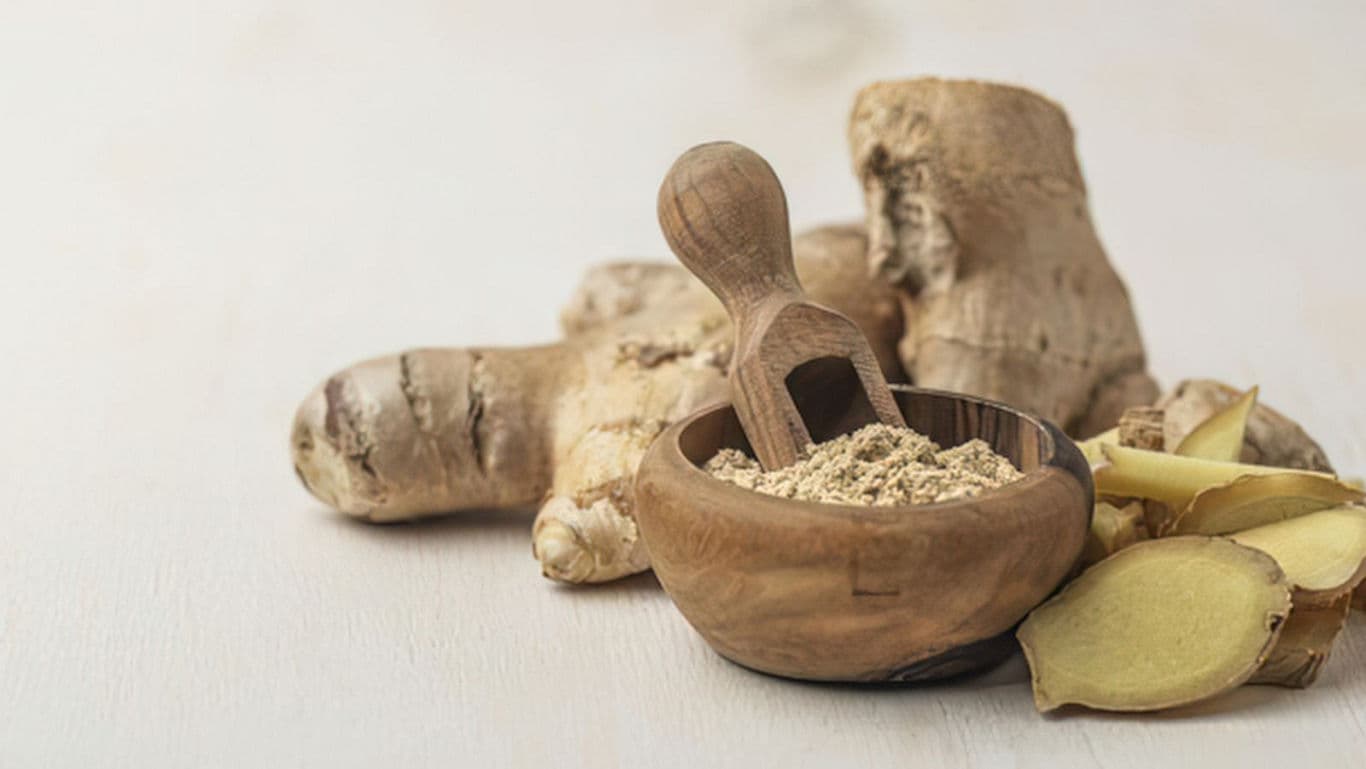 Fresh Ginger Root and Ground Ginger in Wooden Bowl