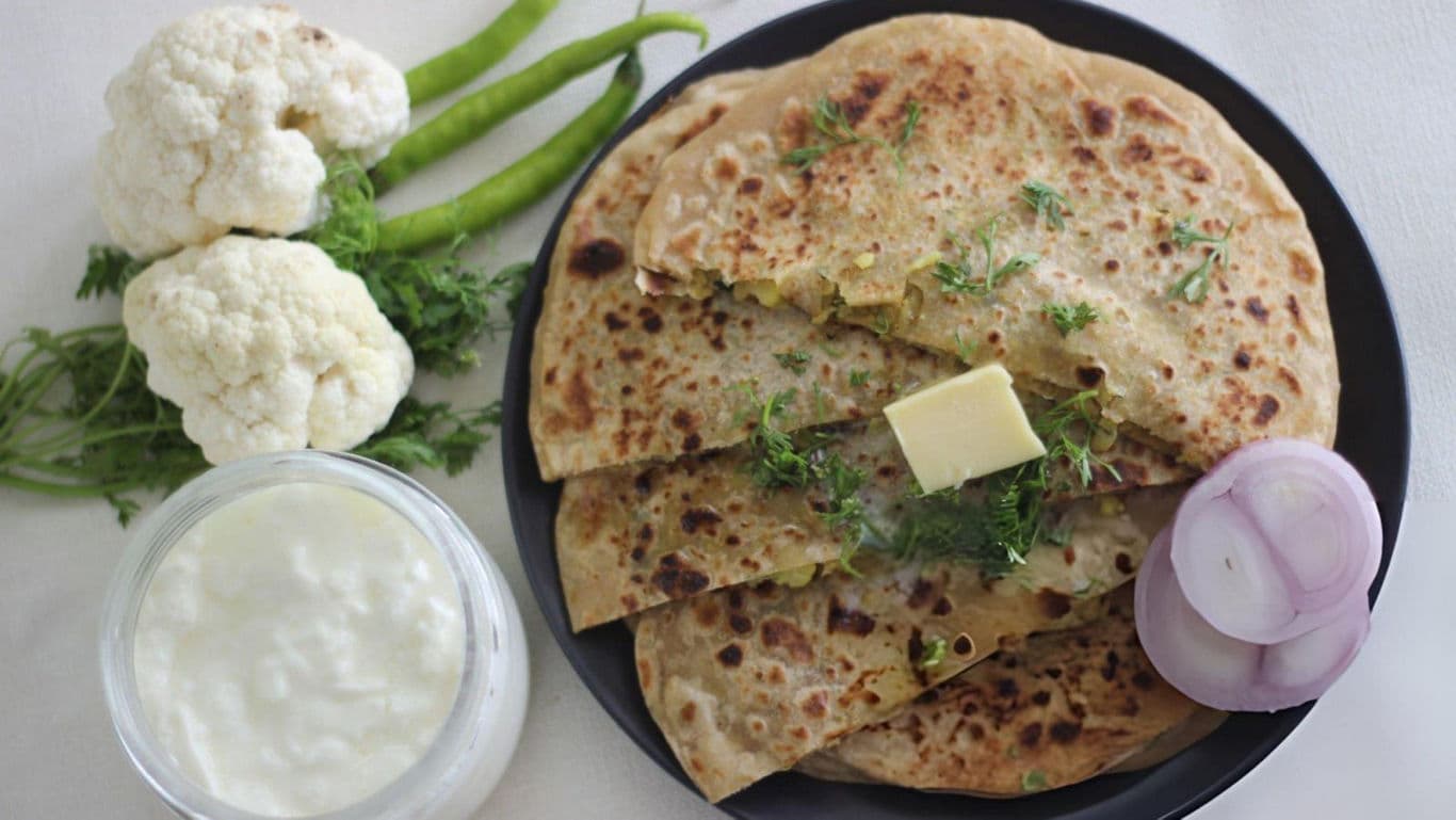 Stuffed paratha with butter, curd, and fresh vegetables