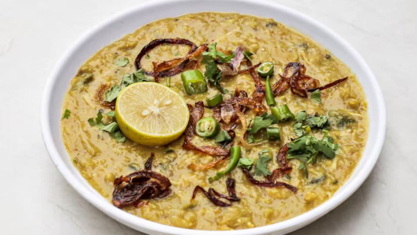 Bowl of Indian dal garnished with lemon and herbs