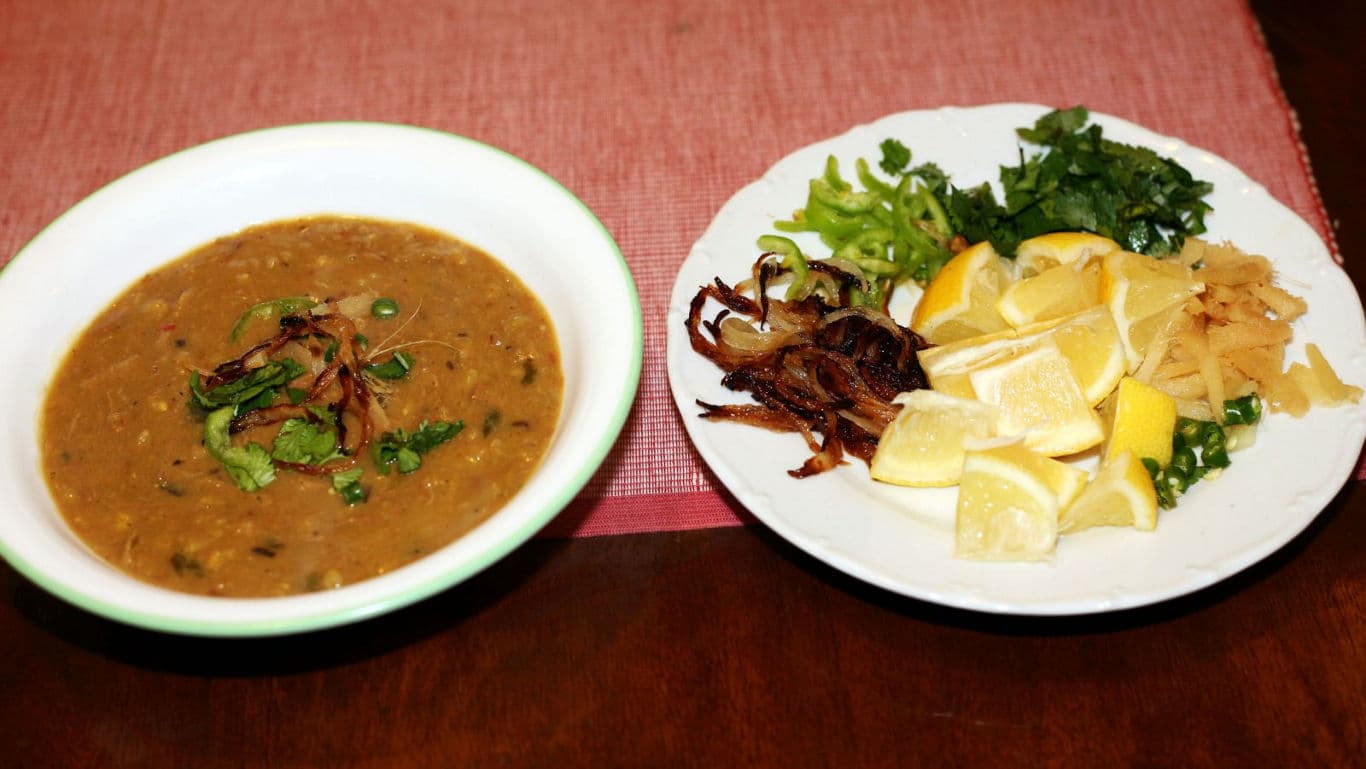 Bowl of lentil soup with fresh garnish plate