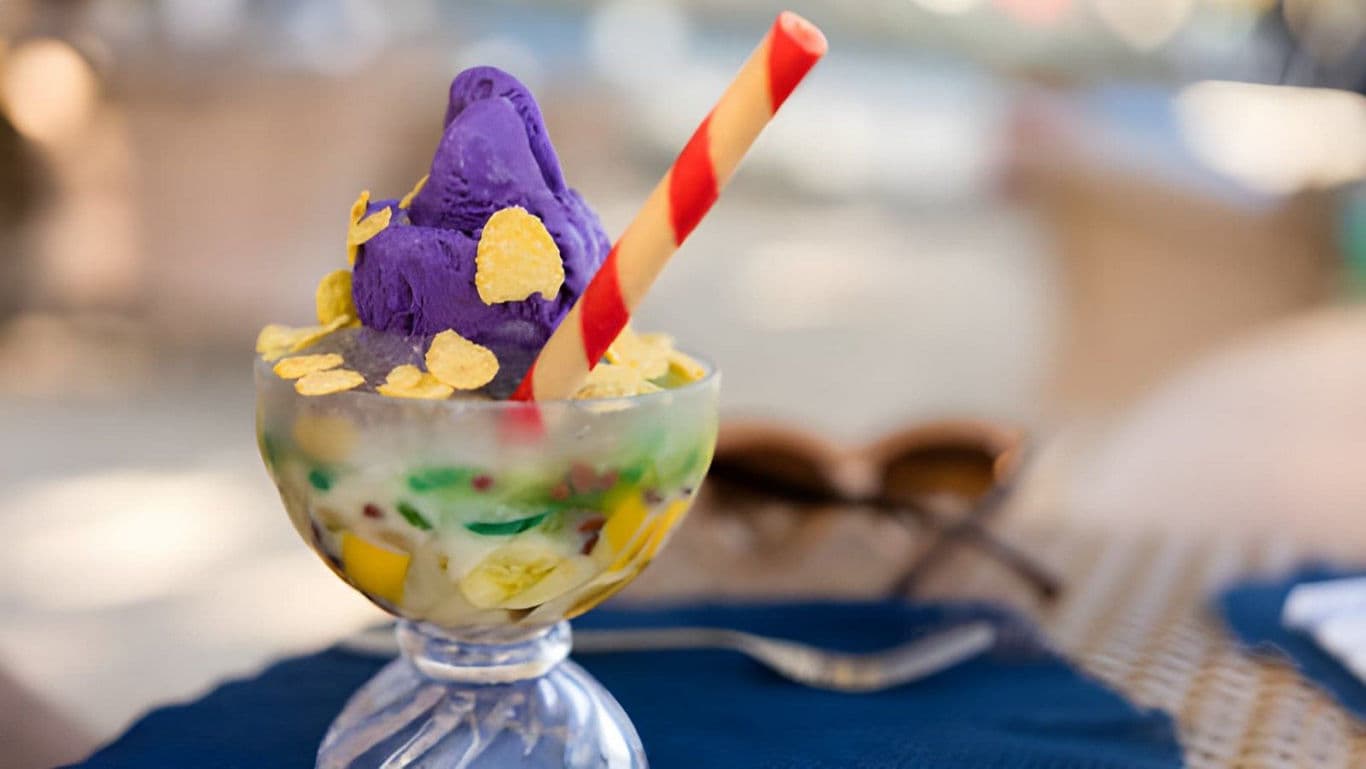 Colorful dessert with purple ice cream and striped straw