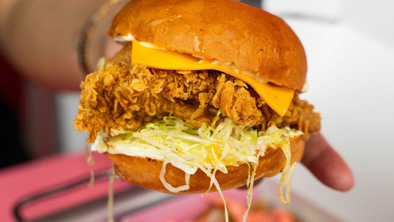 Handheld crispy fried chicken burger closeup