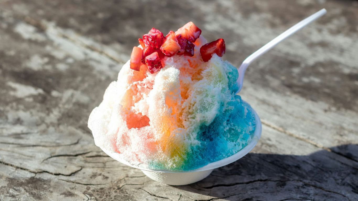 Rainbow shaved ice dessert with fresh strawberries