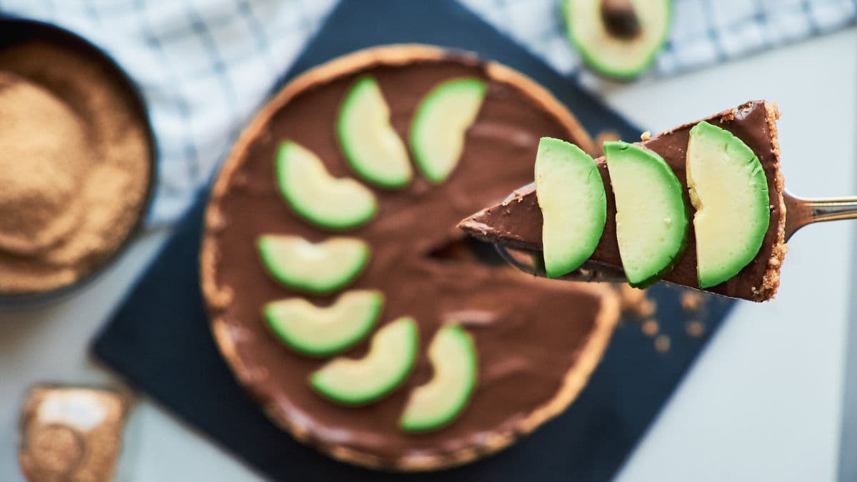 A cake topped with sliced avocados