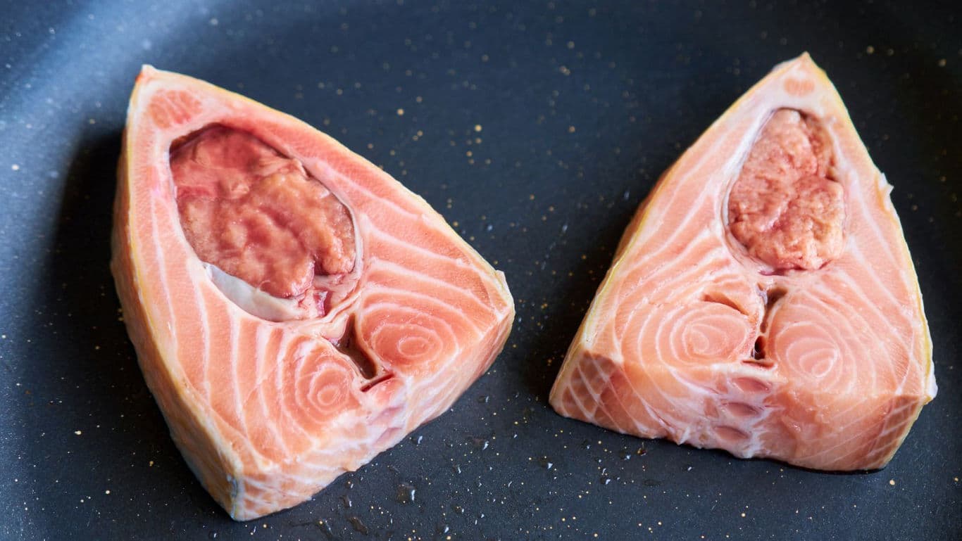 Raw salmon steaks in nonstick frying pan