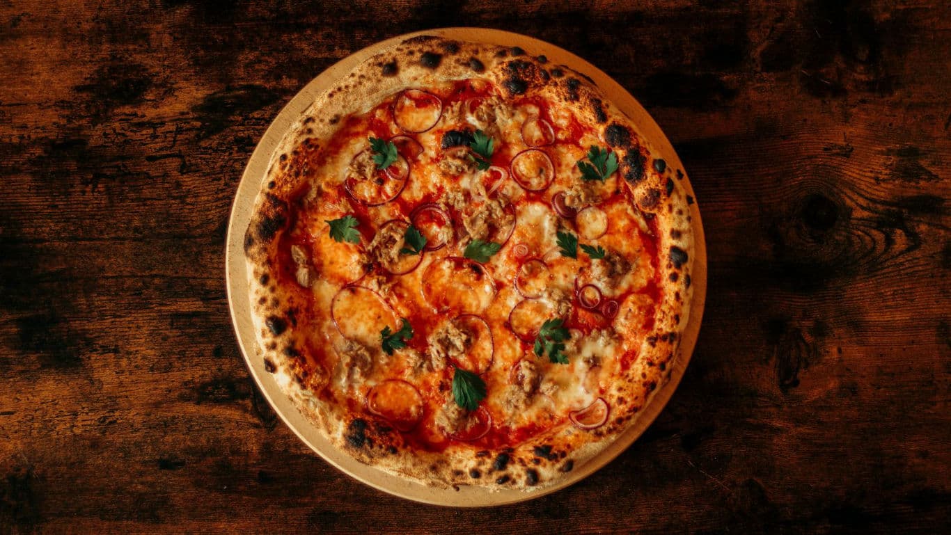 Rustic wood-fired pizza on wooden table
