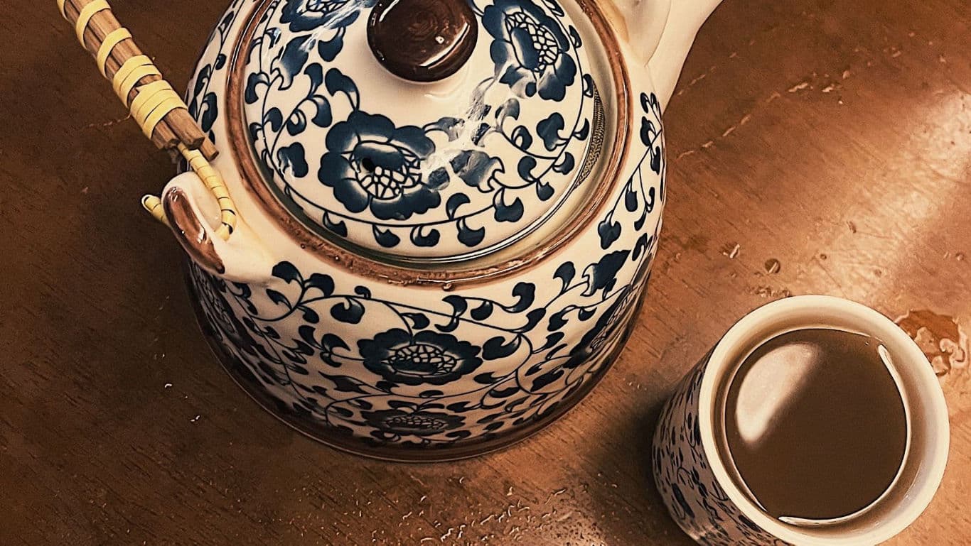 Ornate porcelain teapot with matching teacup