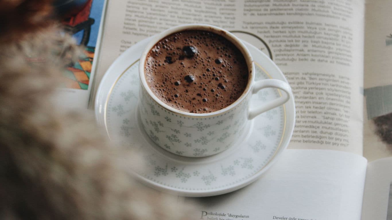 Cup of hot chocolate on open book