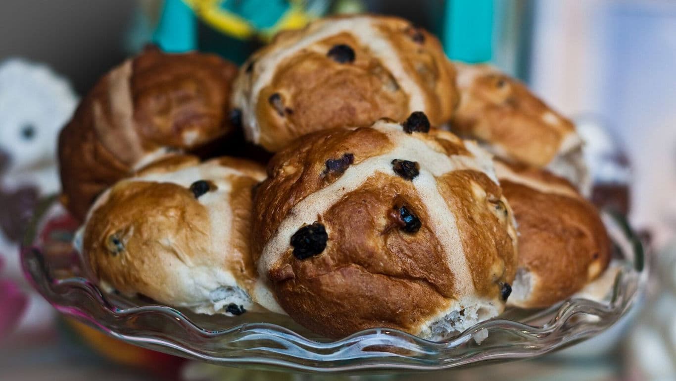 Fresh hot cross buns on glass cake stand