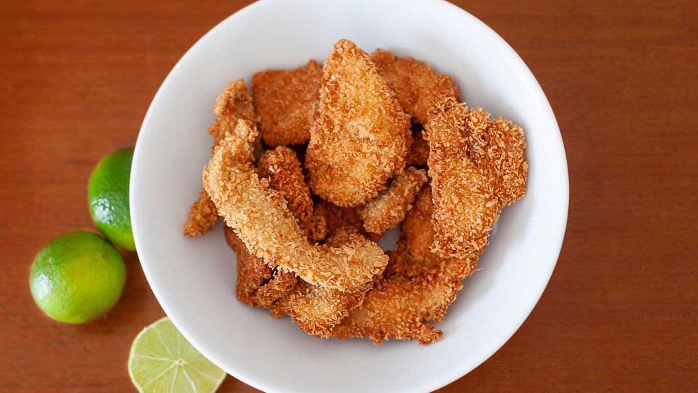 Crispy breaded chicken strips with limes
