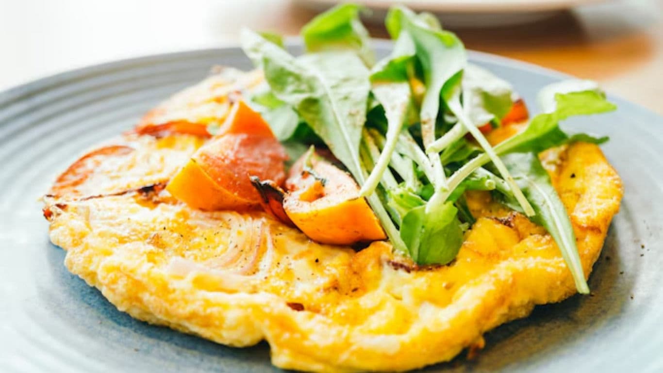 Vegetable omelette topped with fresh arugula greens