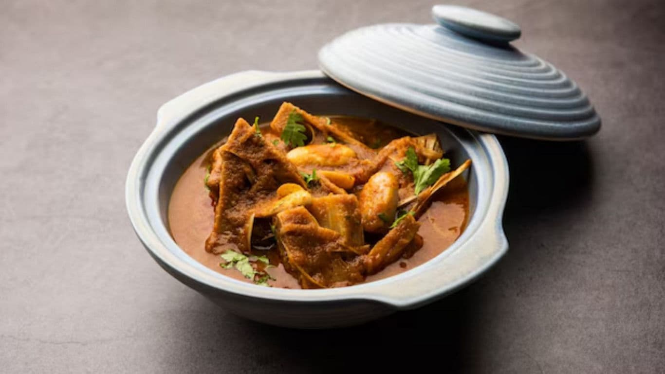 Clay pot with spicy Indian curry and vegetables