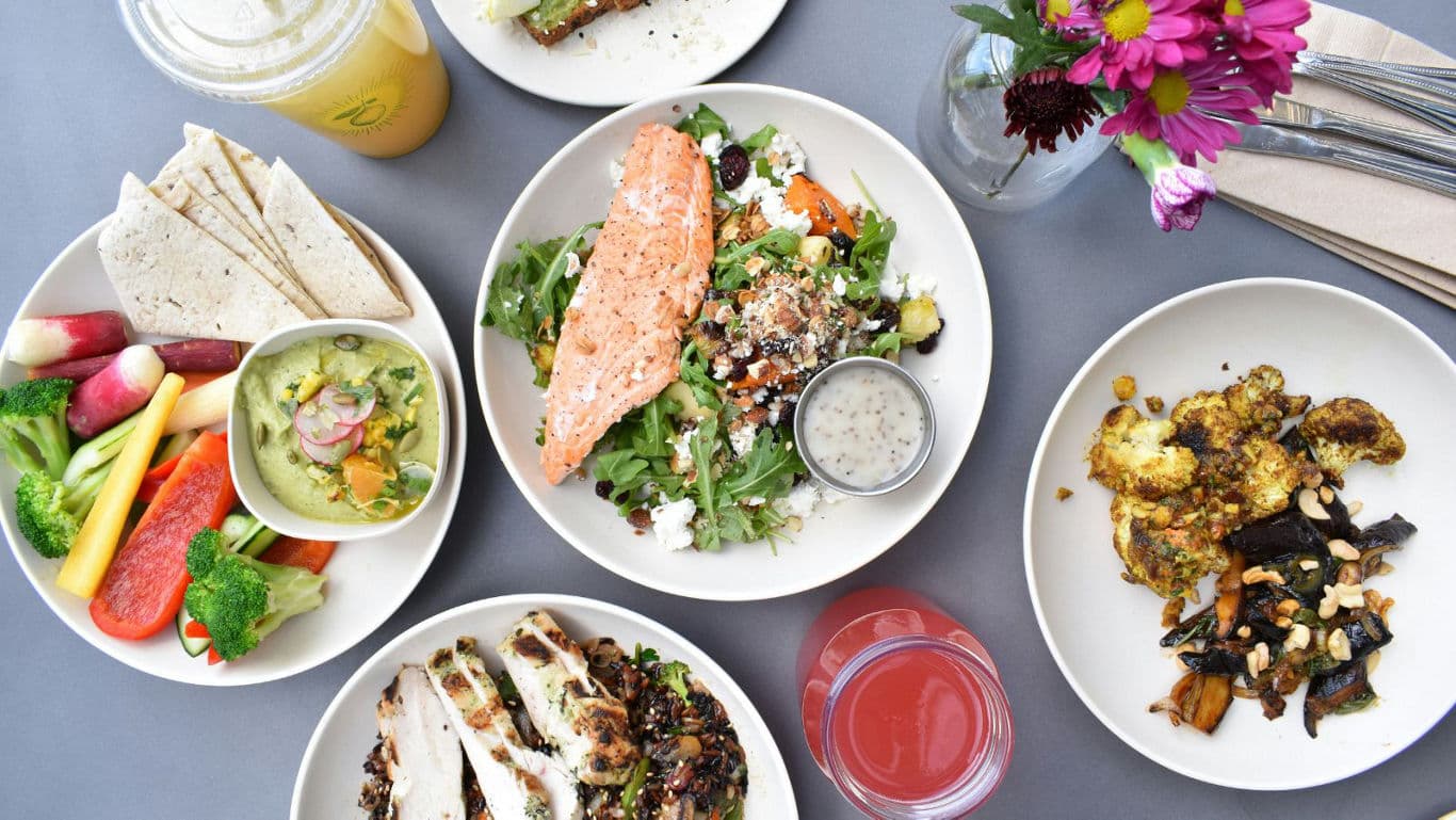 Healthy lunch spread with salads, vegetables, and drinks