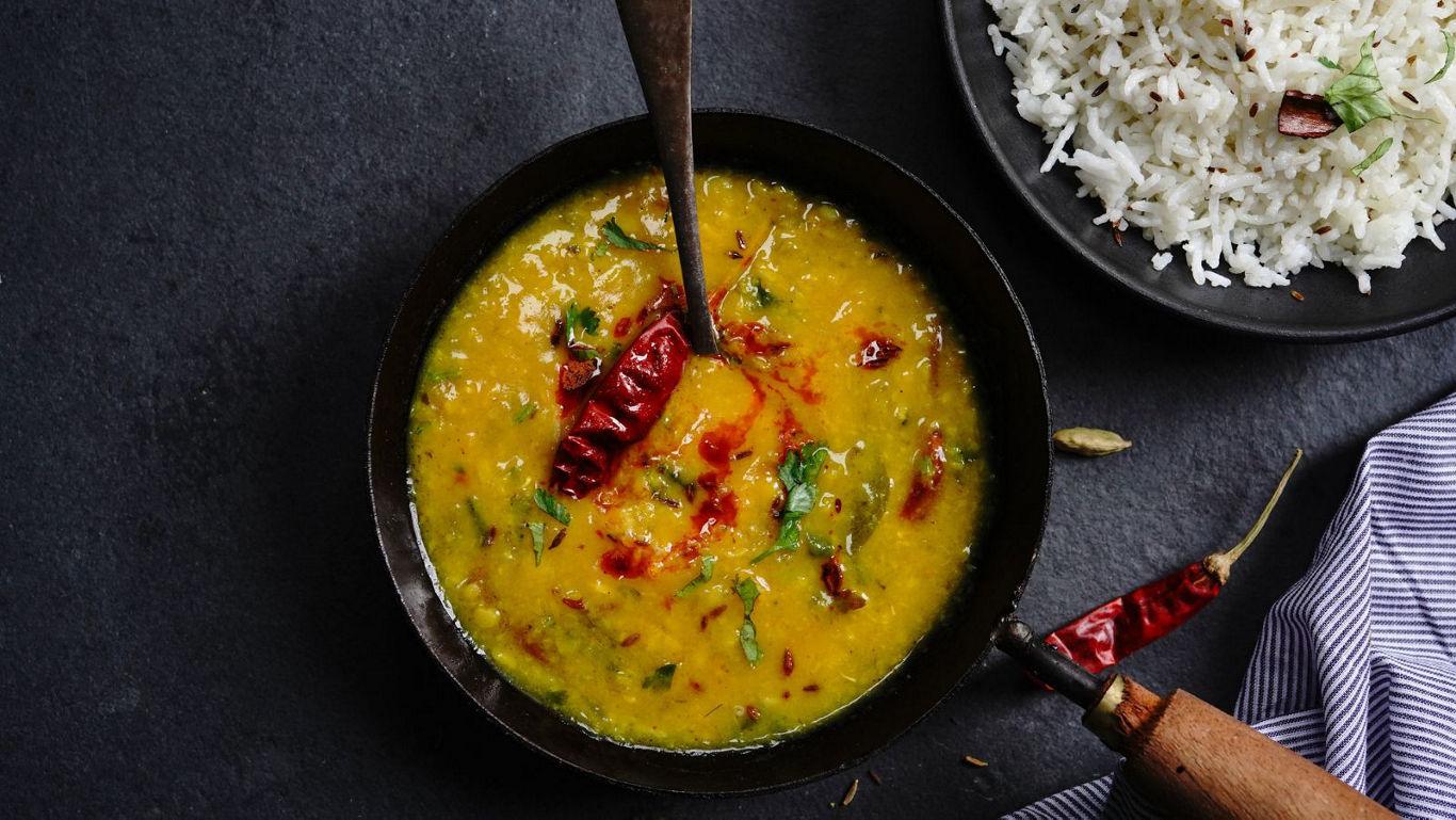 Indian lentil curry with rice on dark table