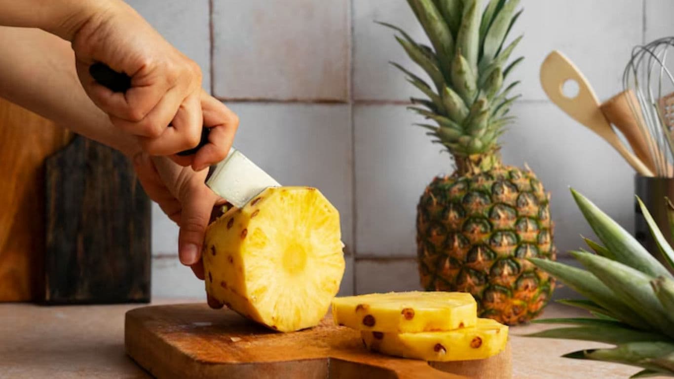 Slicing Fresh Pineapple on Wooden Board
