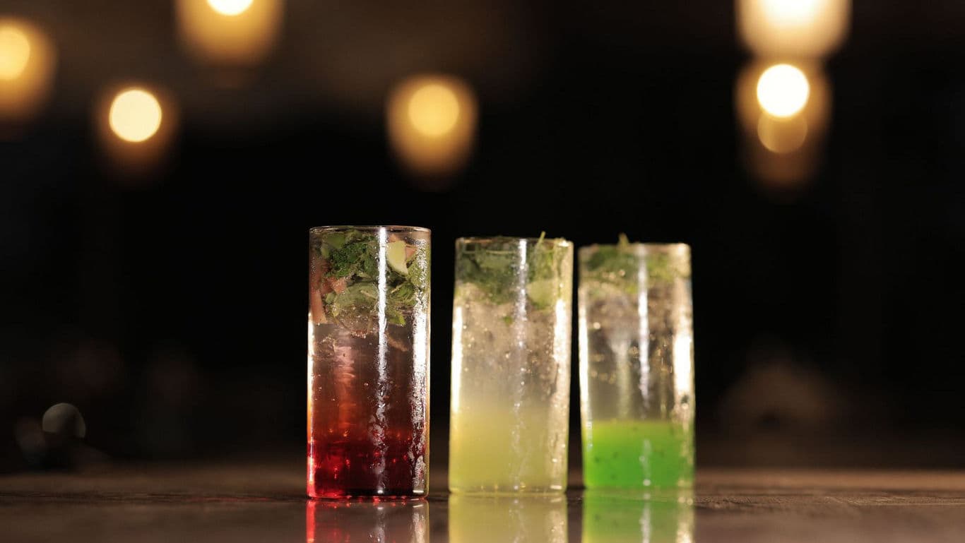 Colorful cocktails in tall glasses at bar