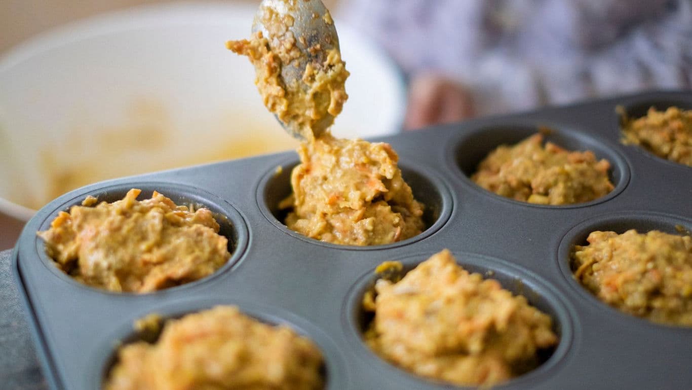 Spoon Filling Muffin Tin With Batter