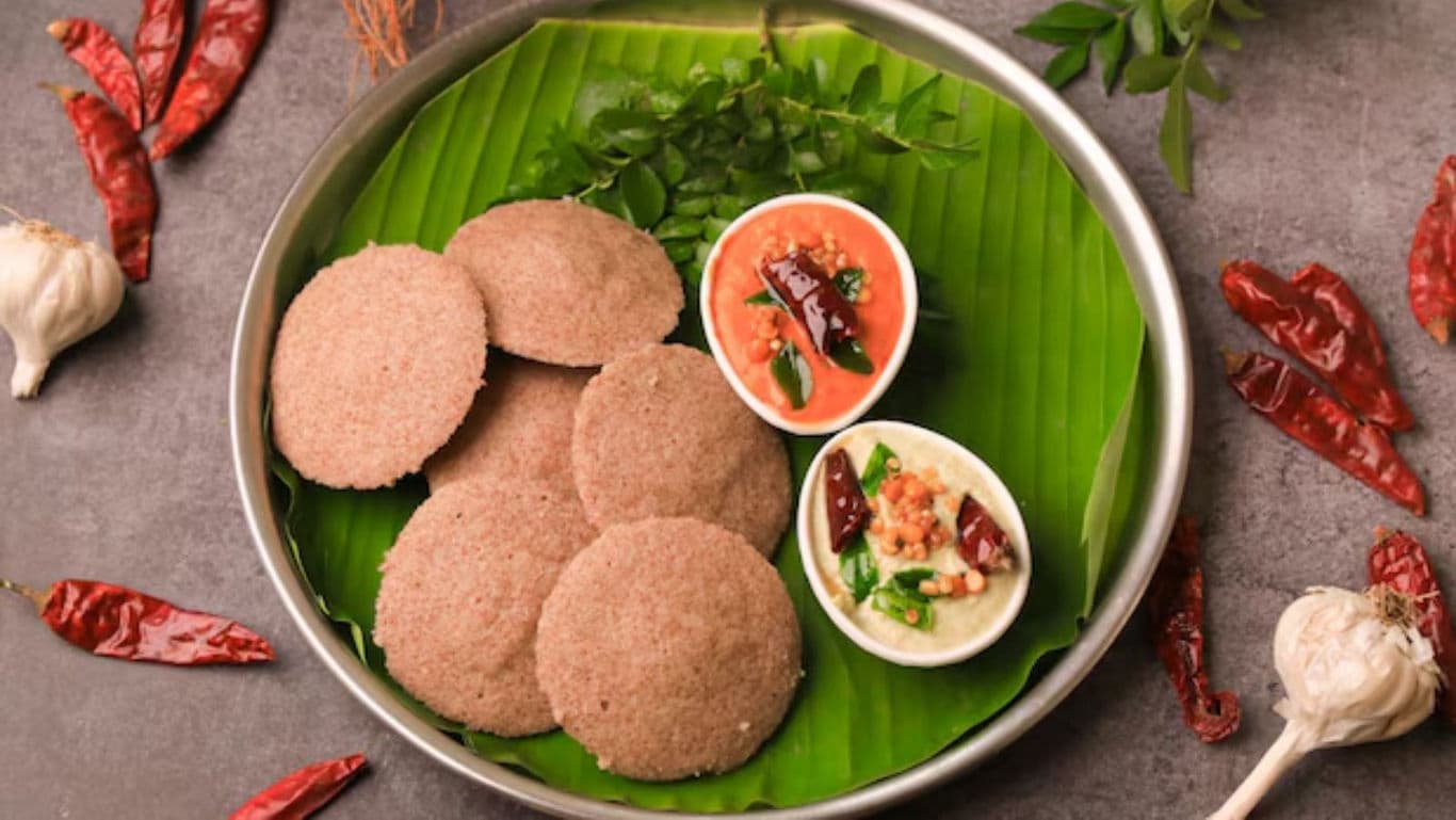 Traditional millet idli served with chutneys on banana leaf