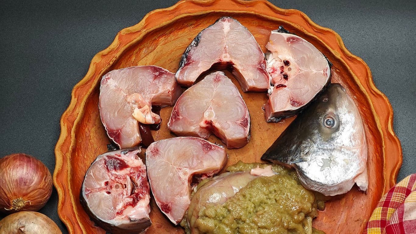 Raw fish steaks and head on platter