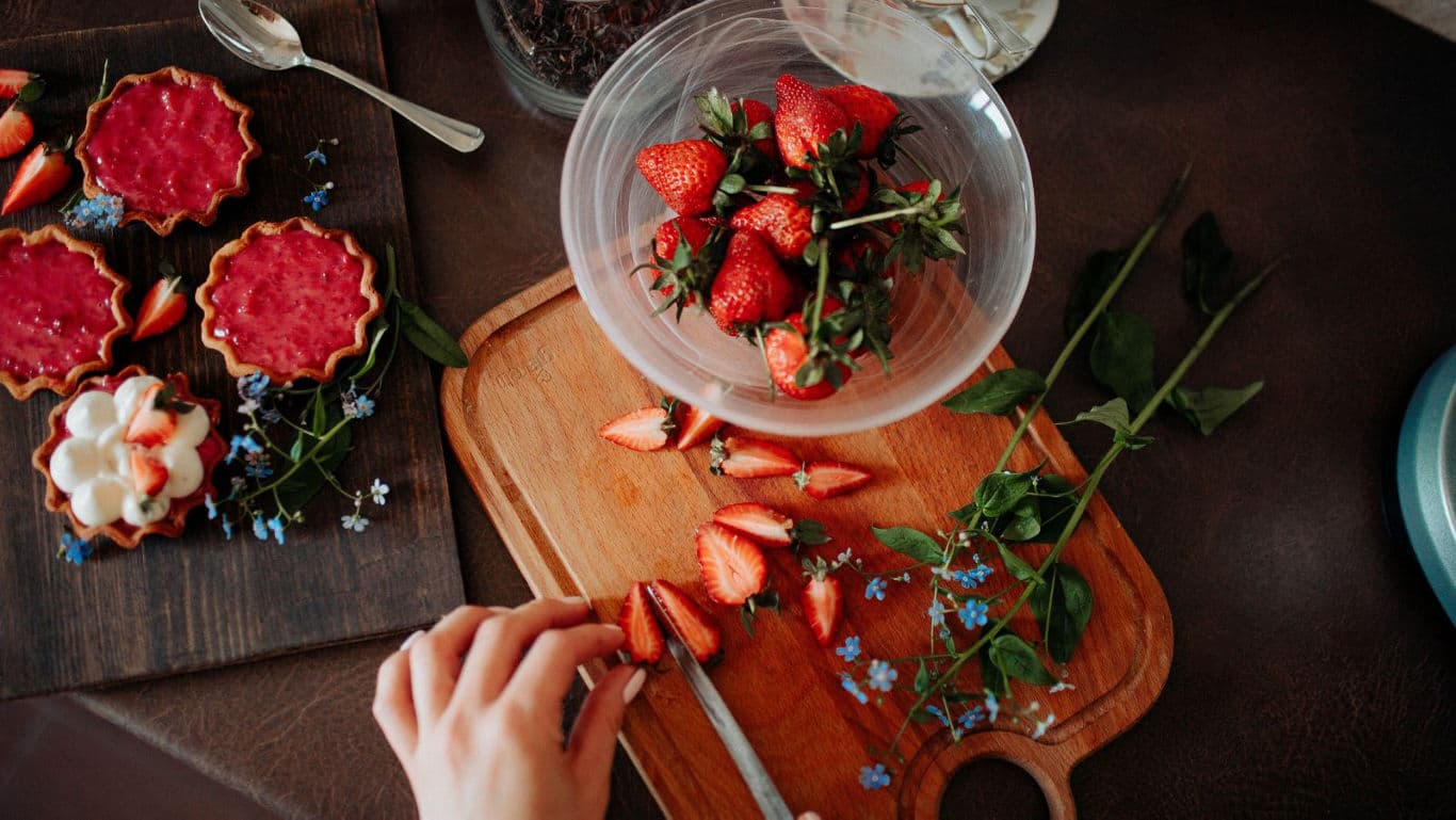 Fresh strawberries and tarts on wooden table