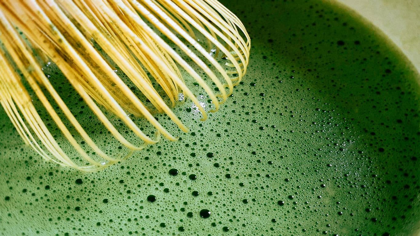 A top-view image of matcha and its preparation tools.