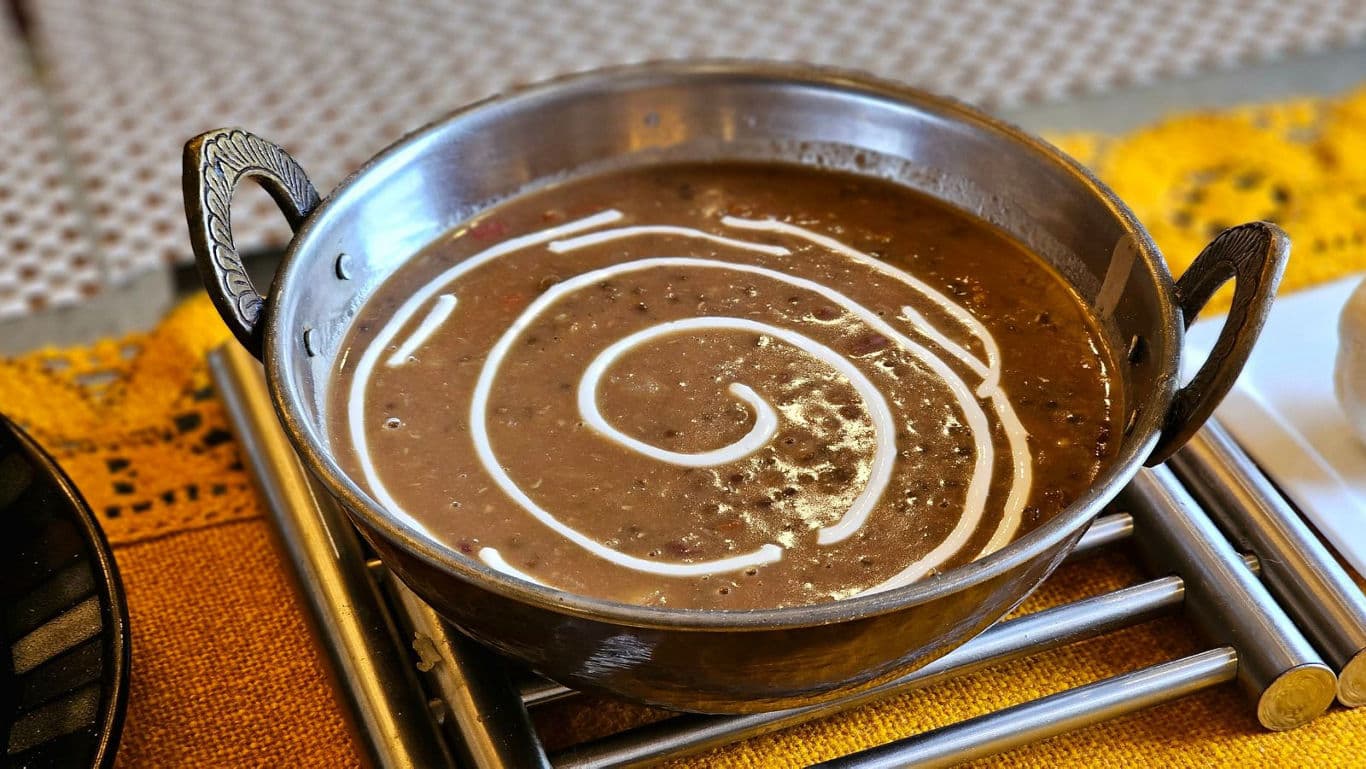 Creamy lentil curry served in metal bowl