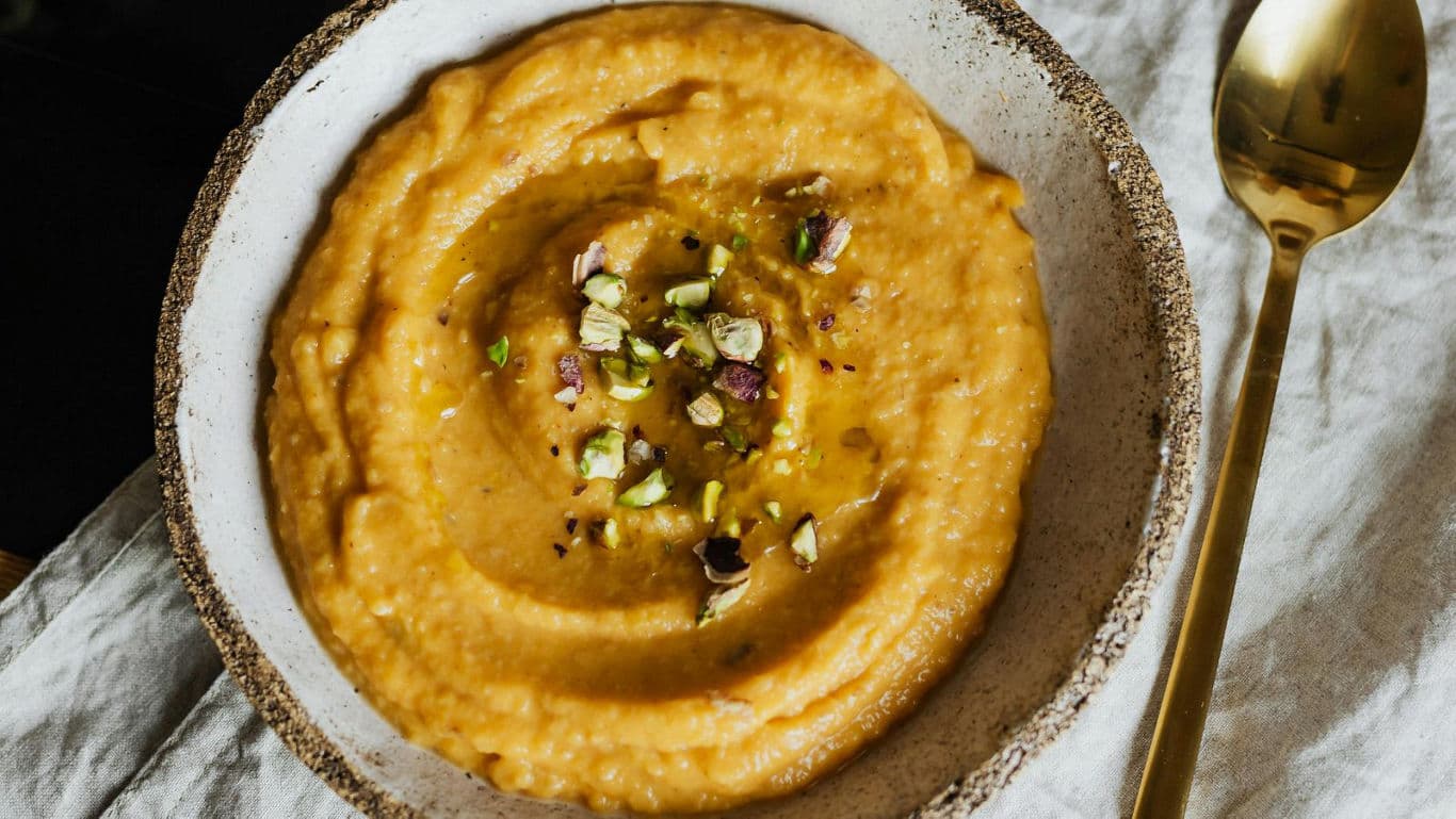 Creamy orange soup garnished with chopped nuts