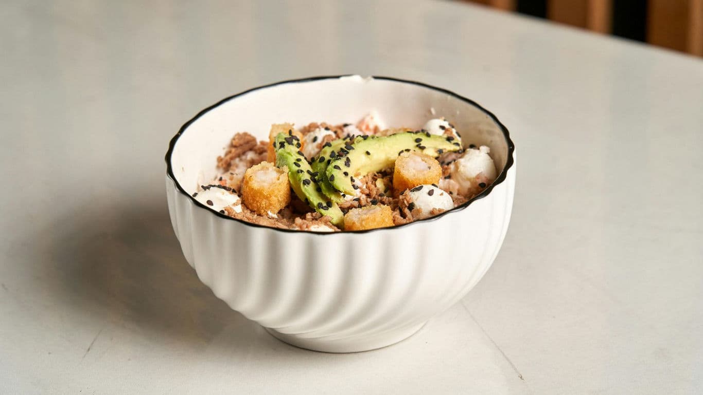 White bowl with savory avocado and grain salad
