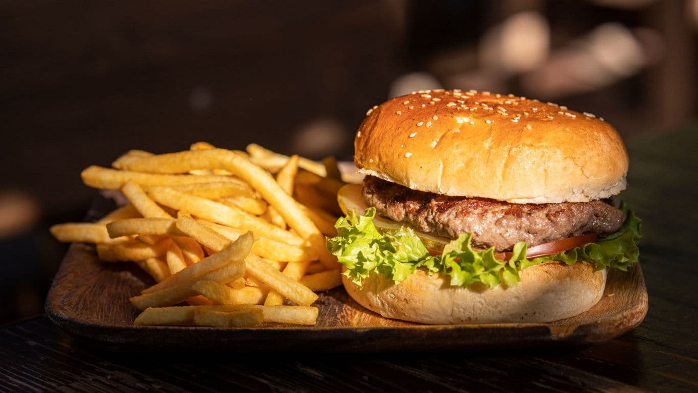 Classic hamburger with fries on wooden tray