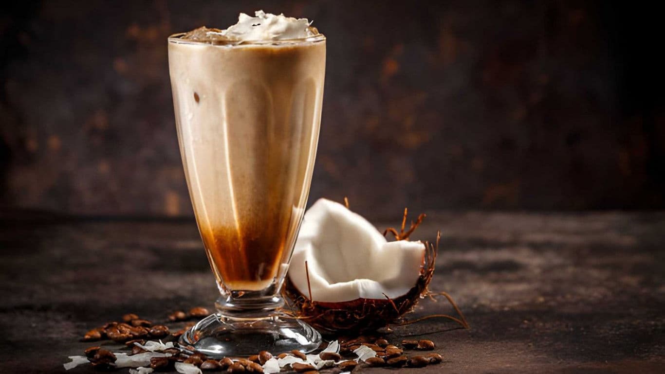 Iced coffee with whipped cream and coconut garnish