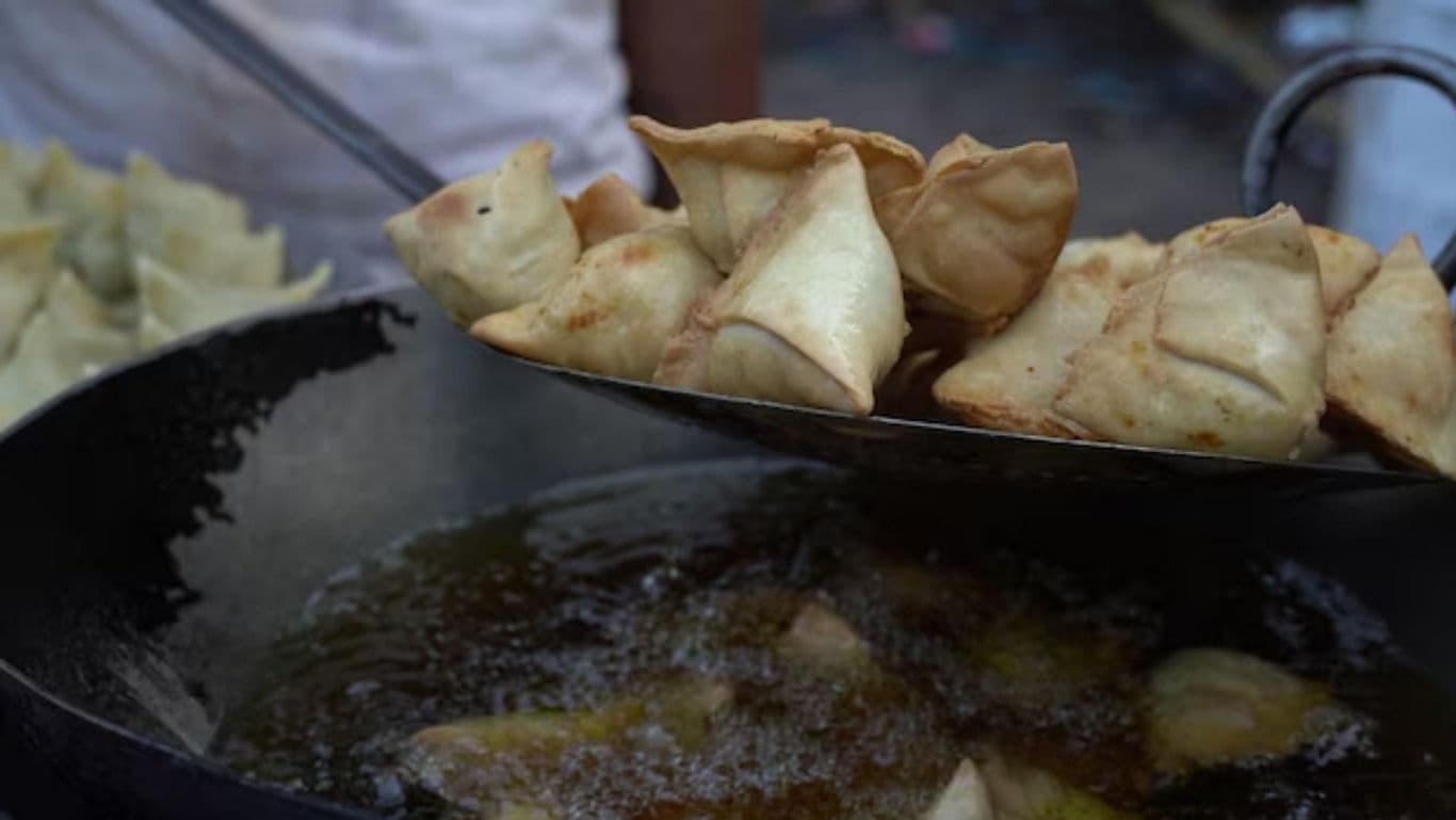 Freshly fried samosas in hot oil
