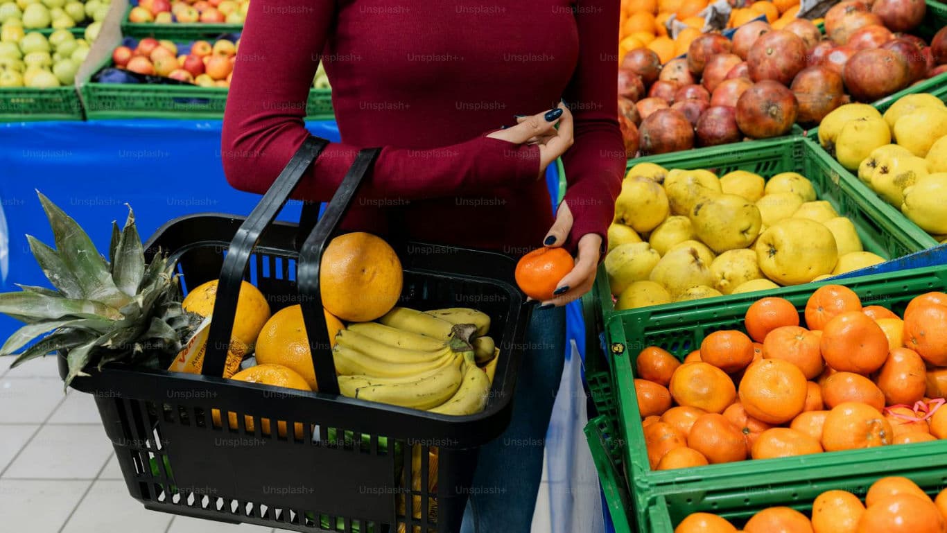 Woman shopping for fresh fruit in supermarket produce aisle