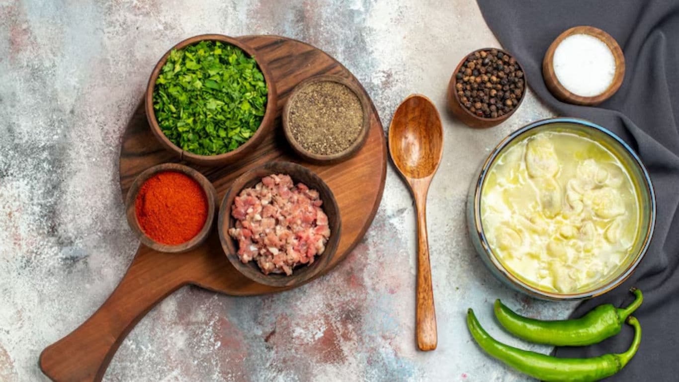 Fresh Ingredients and Dumpling Soup on Rustic Table