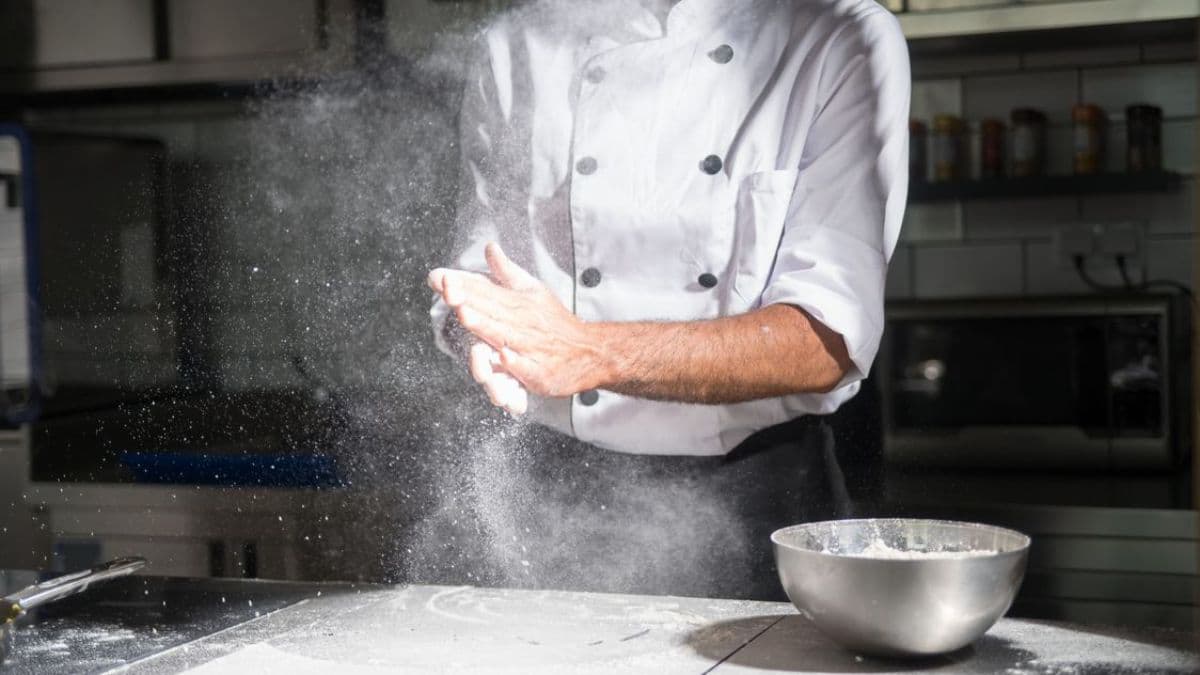 person dusting flour on table