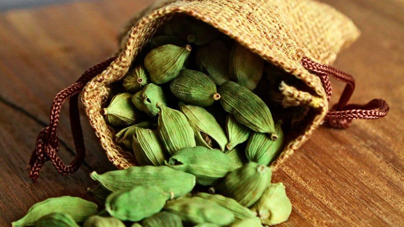 Green Cardamom Pods Spilling from Burlap Sack