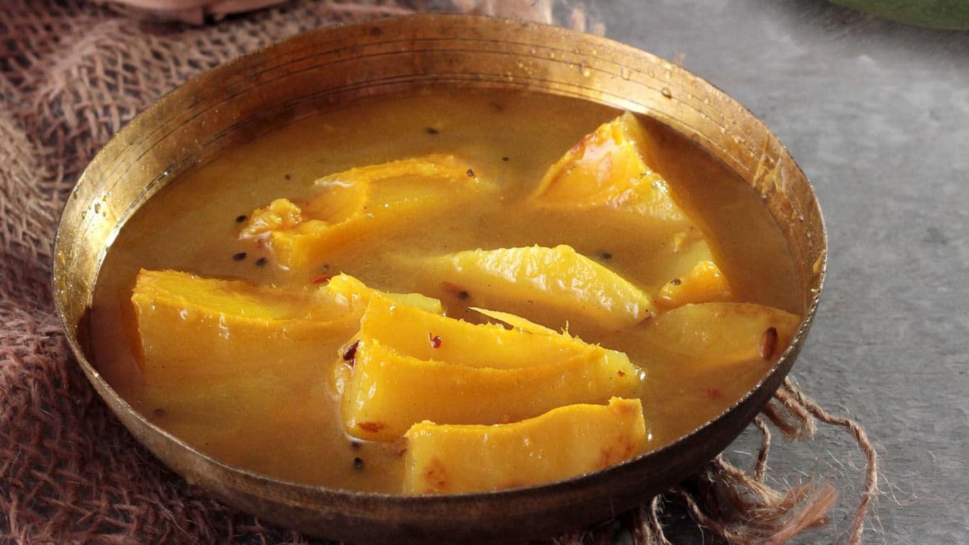 Traditional pumpkin curry in rustic brass bowl