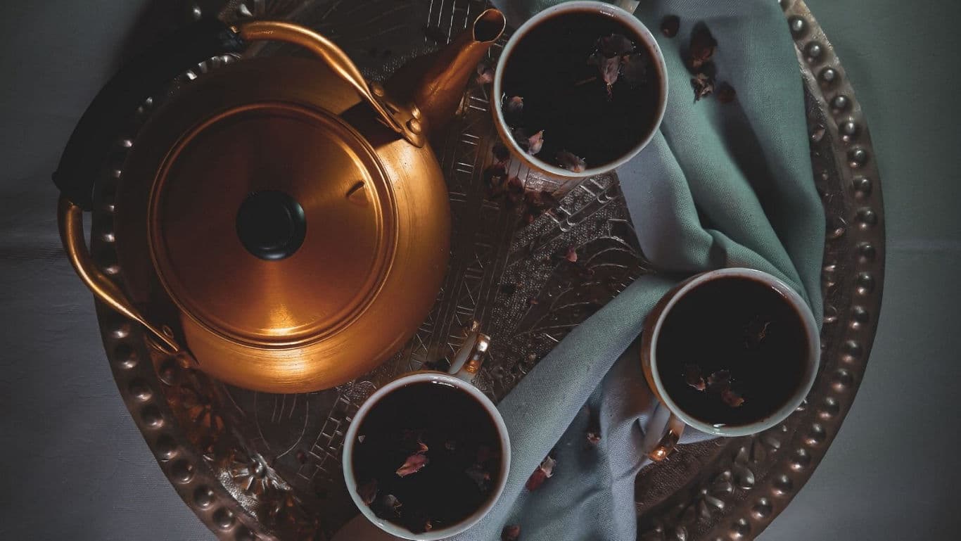 Kahwa tea blend on a bronze plate and bronze kettle
