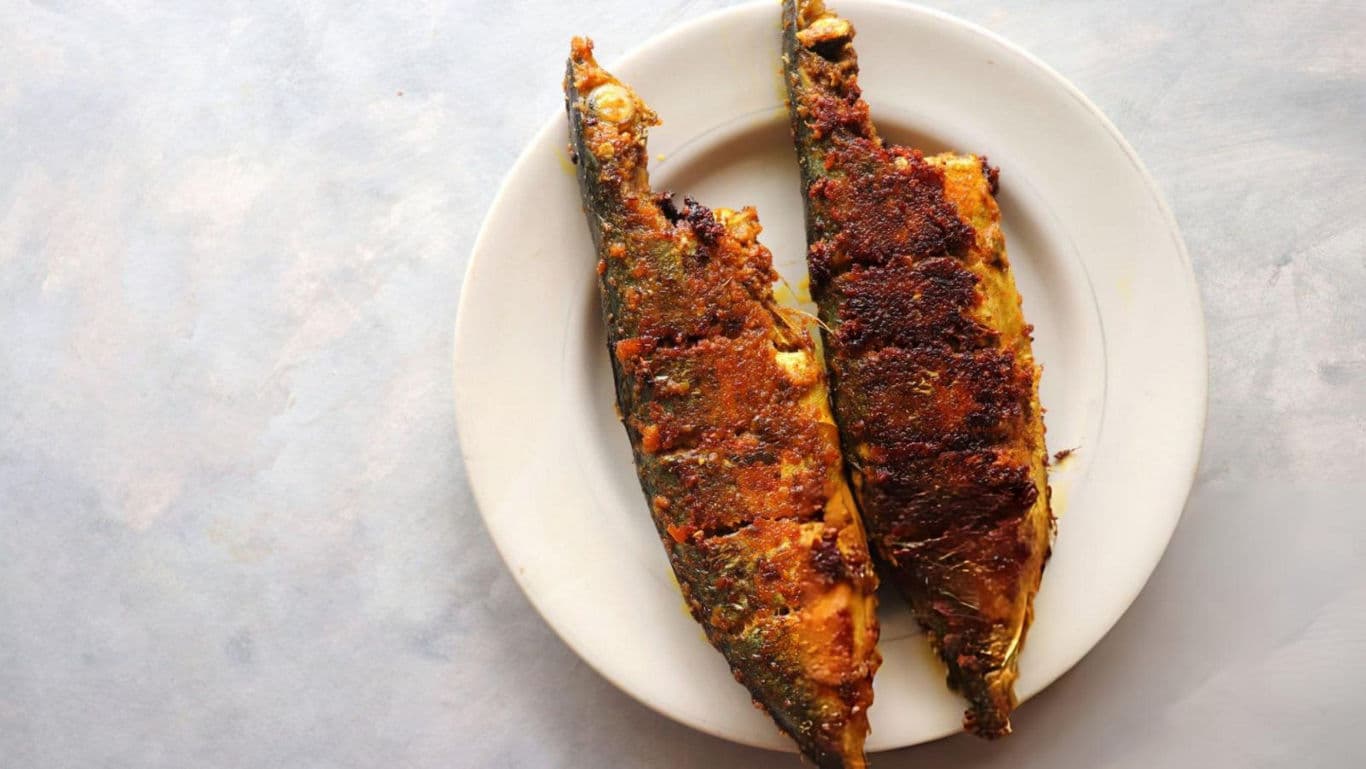 Grilled fish served on white plate