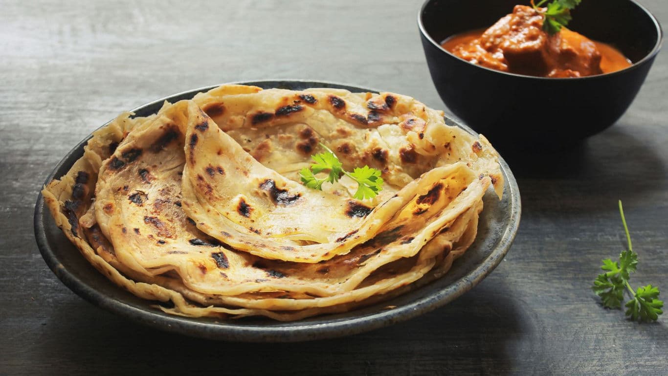 Stack of flaky flatbreads with curry