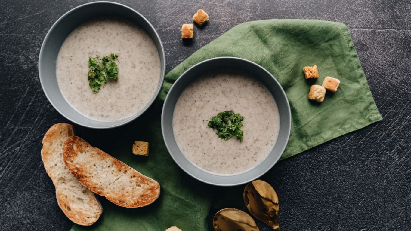 Creamy soup bowls with bread and croutons