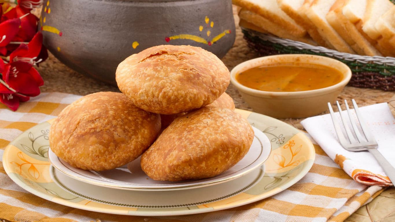 Stack of Indian kachoris served with curry and bread