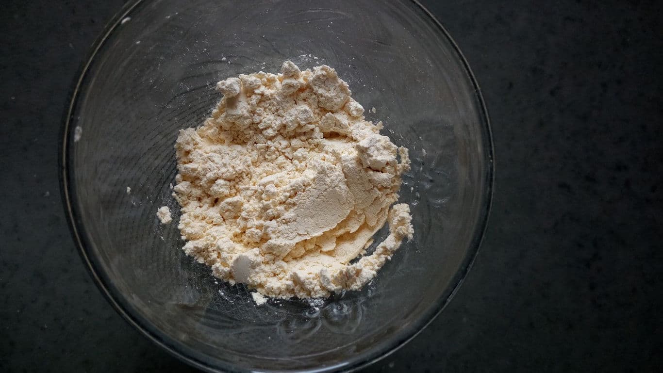 Bowl of dry flour on dark surface