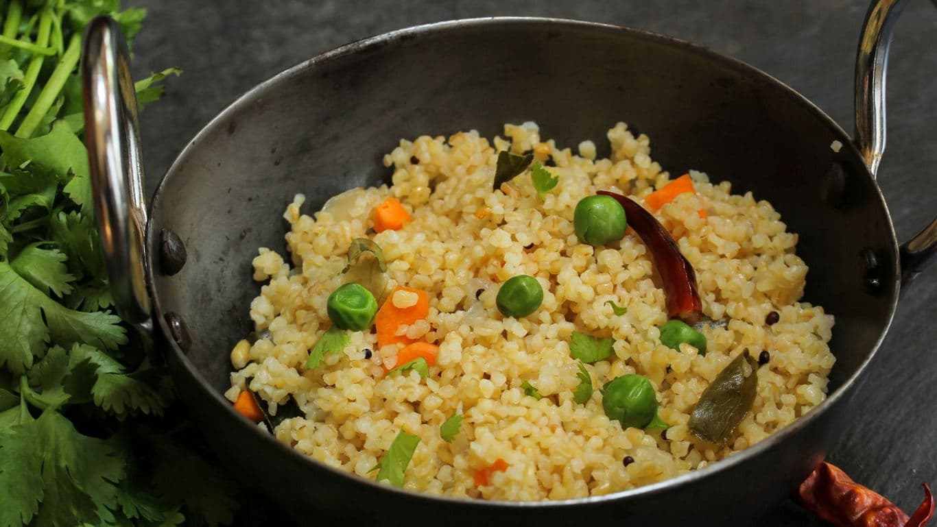 Vegetable millet pulao served in traditional metal bowl