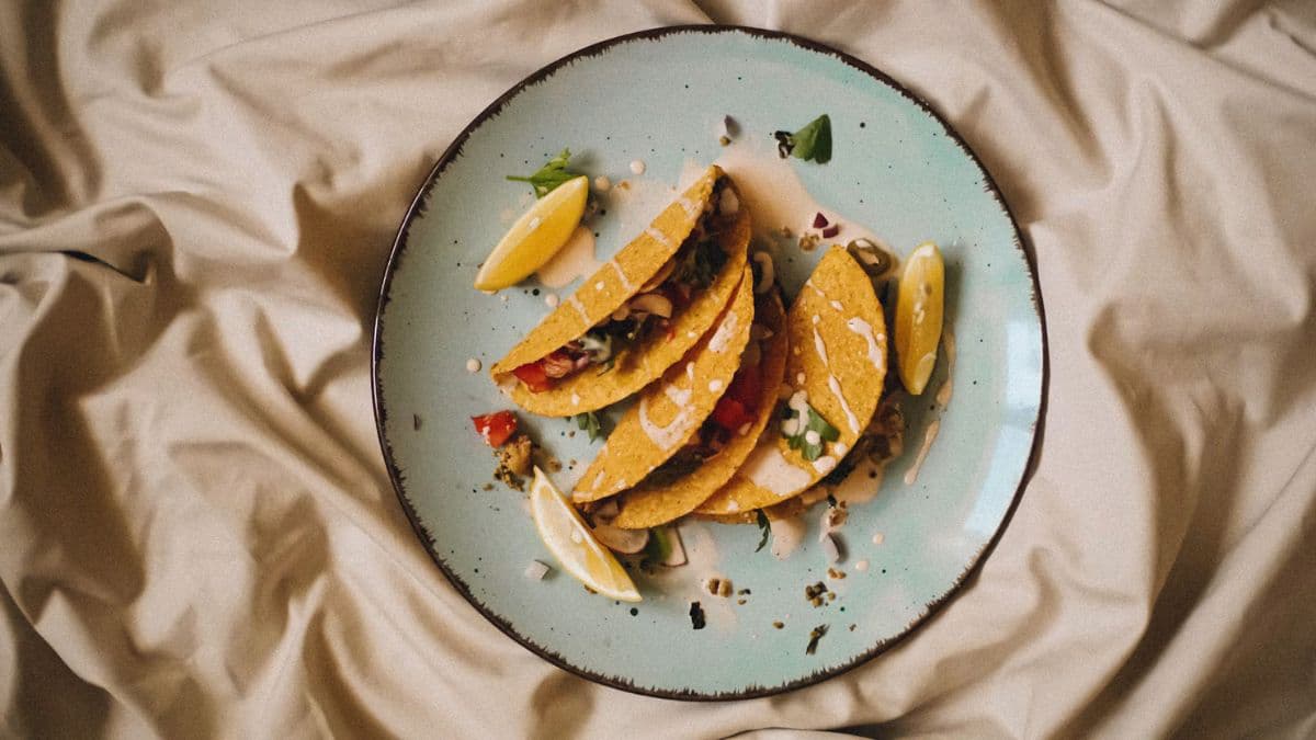 a plate with three crunchy tacos