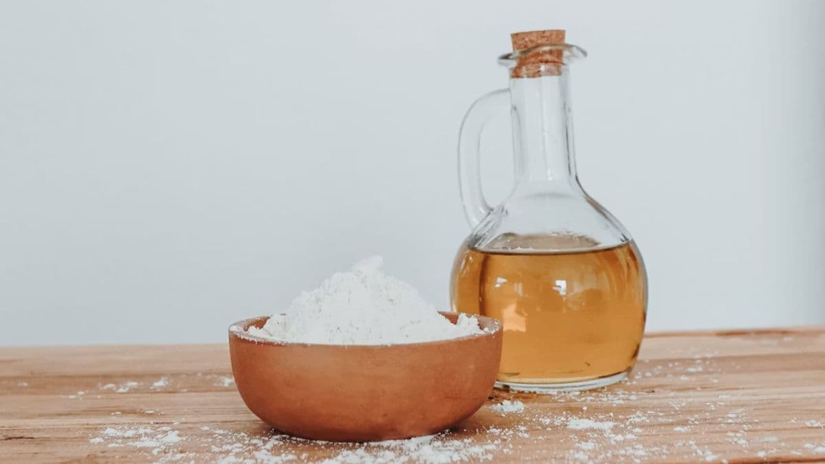 A bowl of flour with a bottle of oil
